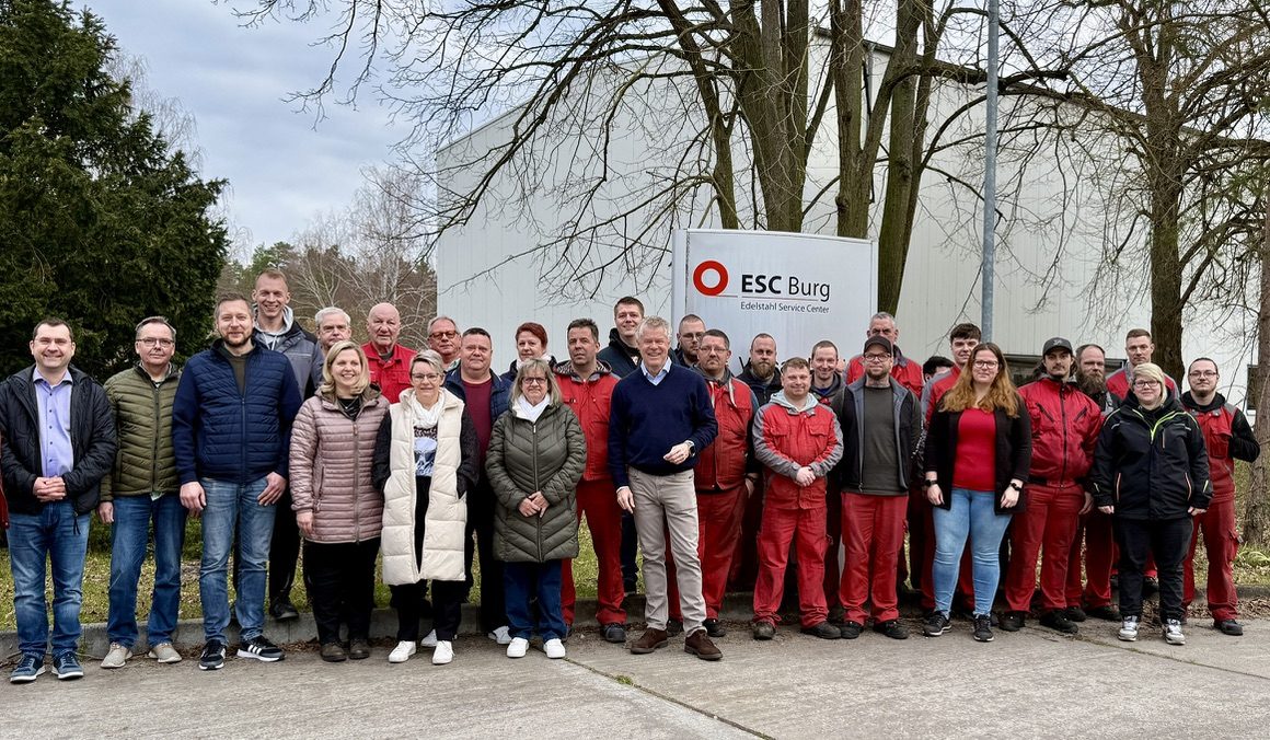 Belegschaft der ESC Burg vor dem Firmenschild am Werkseingang