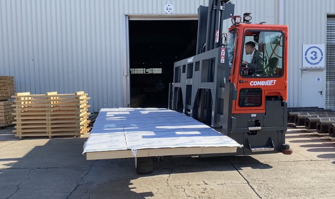 Seitenstapler verlädt ein verpacktes Blechpaket vor der Halle