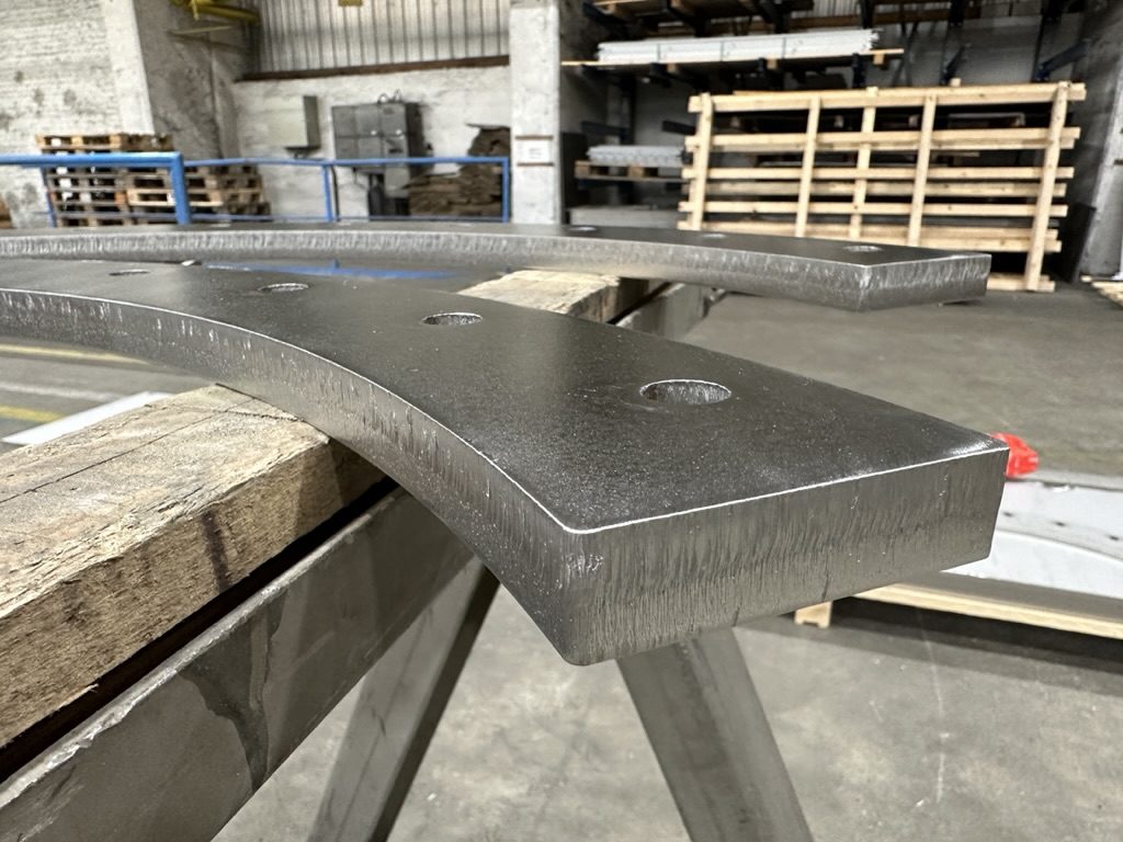 Gebogenes Konturbauteil aus dickem Edelstahlblech mit Bohrungen