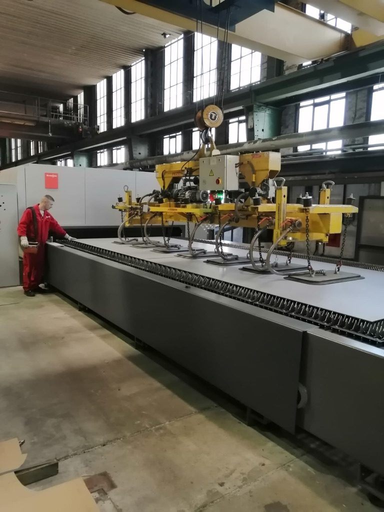 Vakuumheber belädt den Schneidtisch der Faserlaseranlage mit einer Edelstahltafel