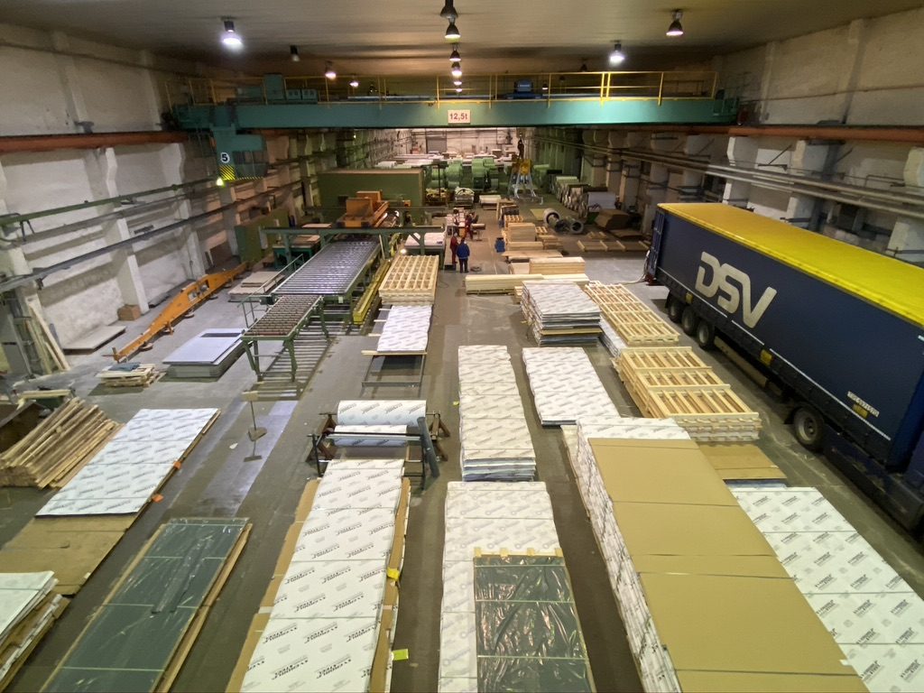 Blick in die Versandhalle mit kommissionierten Blechpaketen und LKW an der Rampe